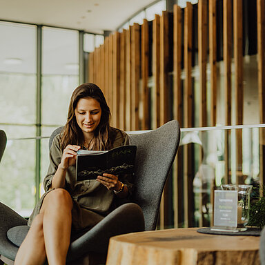 A woman browses through brochures and magazines at the Lürzerhof.