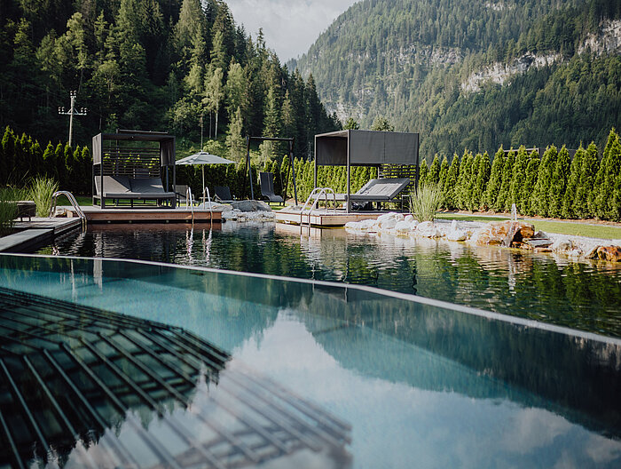 The outdoor pool in the adults-only area with comfortable loungers at the Lürzerhof wellness hotel in Salzburg