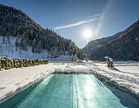 Der Outdoorpool im Winter des Wellnesshotels Lürzerhof in Salzburg