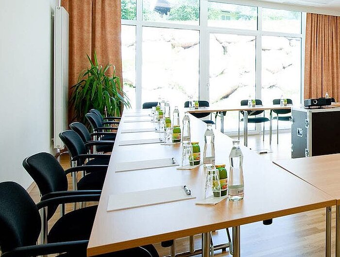 Bright seminar room with full seating and drinks at every seat