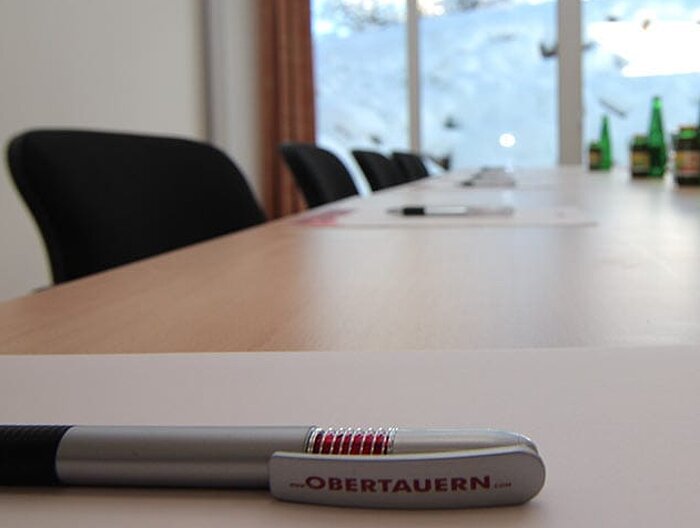 Modern seminar room with conference table, writing materials, and a view of the snow-covered landscape at Hotel Lürzerhof