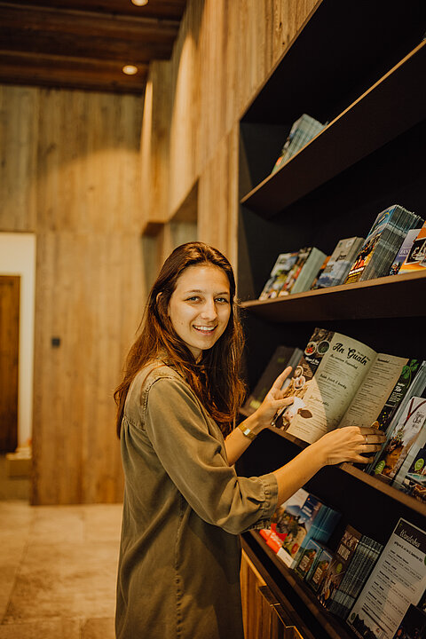 A woman browses through brochures and magazines at the Lürzerhof.