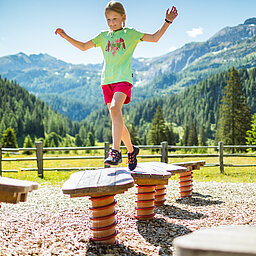 A girl plays in a playground on the Alles Alm adventure trail.