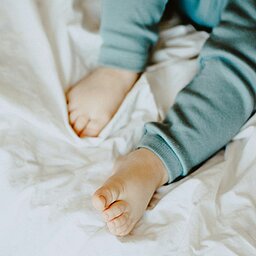 Baby feet on a white blanket in cozy sleepwear