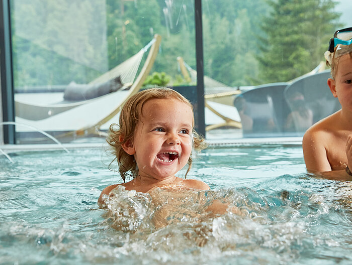 Children splash around in the indoor pool at the Lürzerhof wellness hotel in Salzburg.