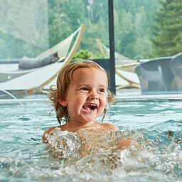 Children splash around in the indoor pool at the Lürzerhof wellness hotel in Salzburg.