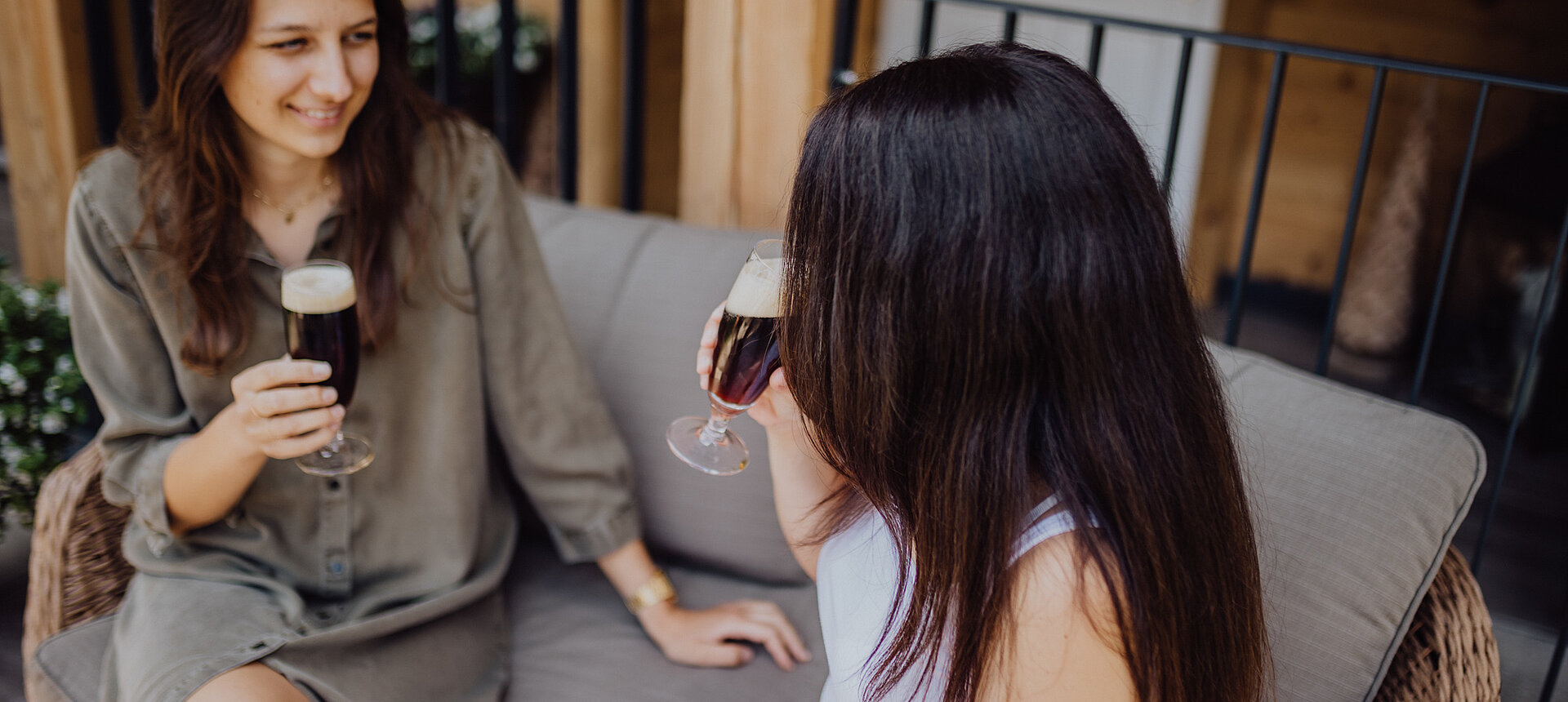 Two women clink glasses on the terrace of the Lürzerhof.