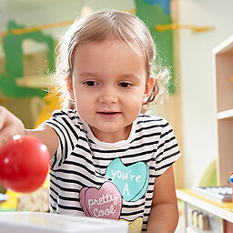 Toddler playing in the play kitchen at the Lürzerhof, the family hotel in Austria for vacations with children.
