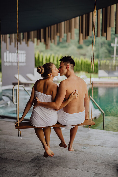 A couple sits on the swing in the adults-only area of the Lürzerhof wellness hotel in Salzburg.