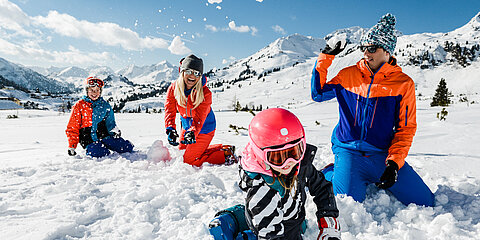 Family having fun in the snow on an active vacation in Austria