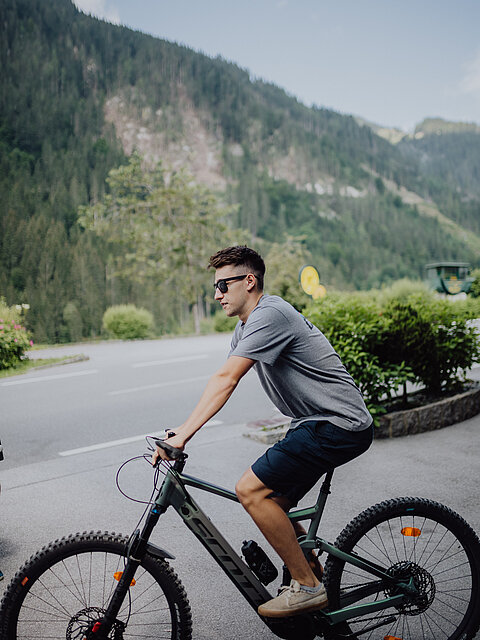 A man on a bicycle in front of the Lürzerhof