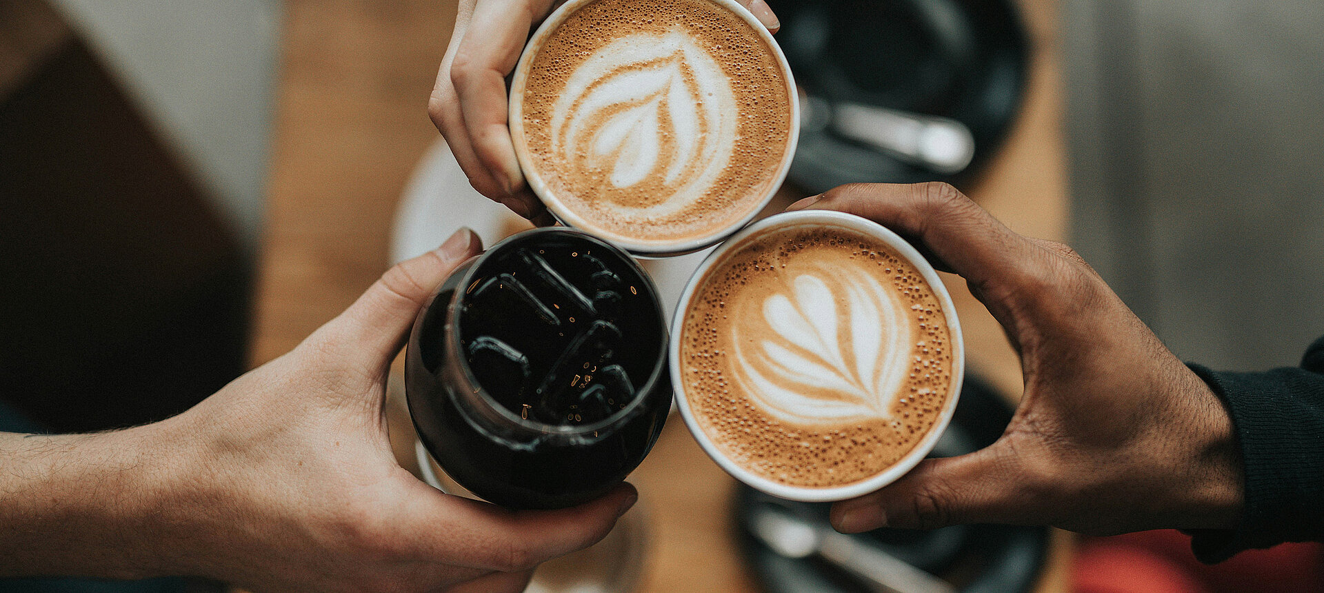 Zwei Cappuccinos und ein weiteres Getränk im Cheers-Moment