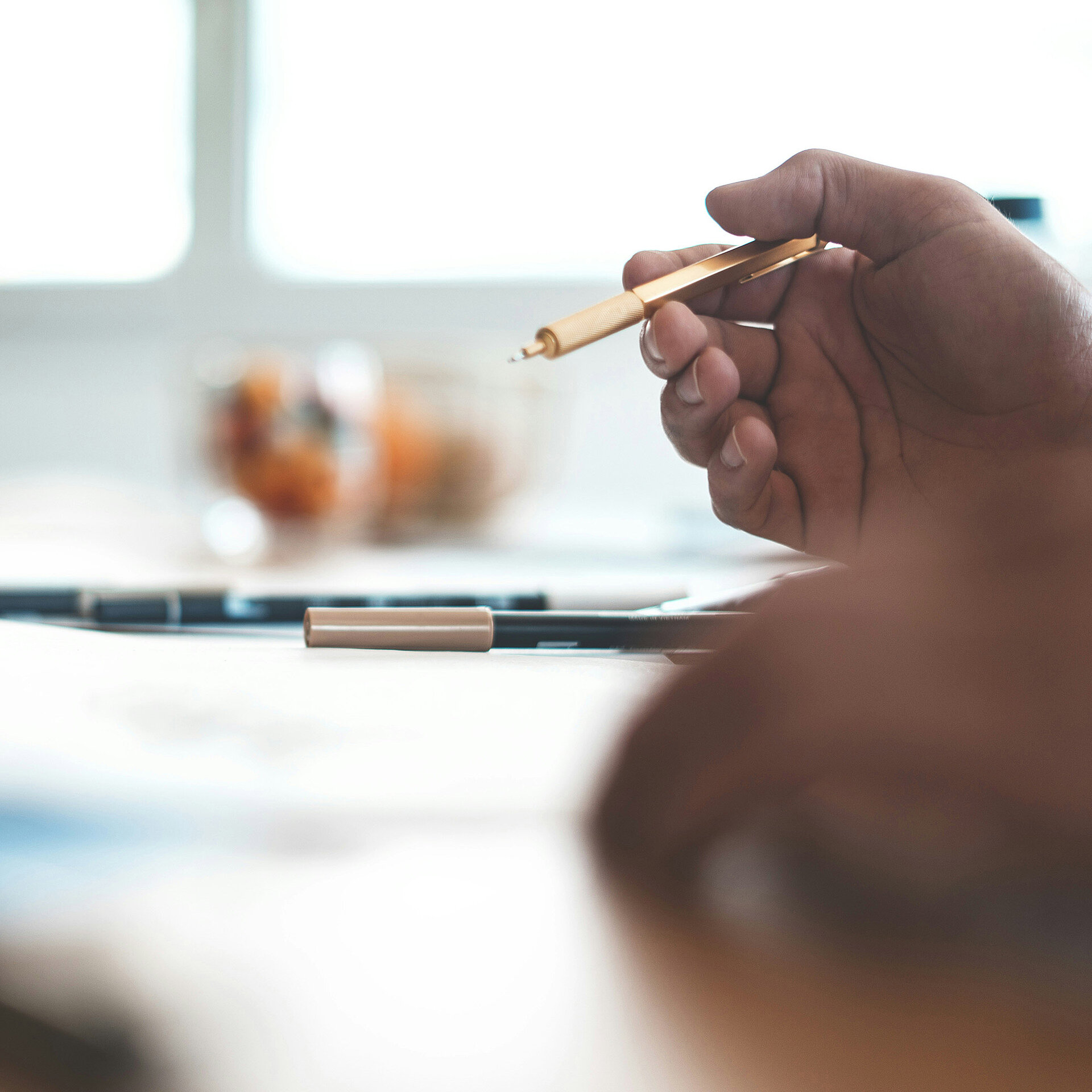 Meeting at a table with focus on pen and documents