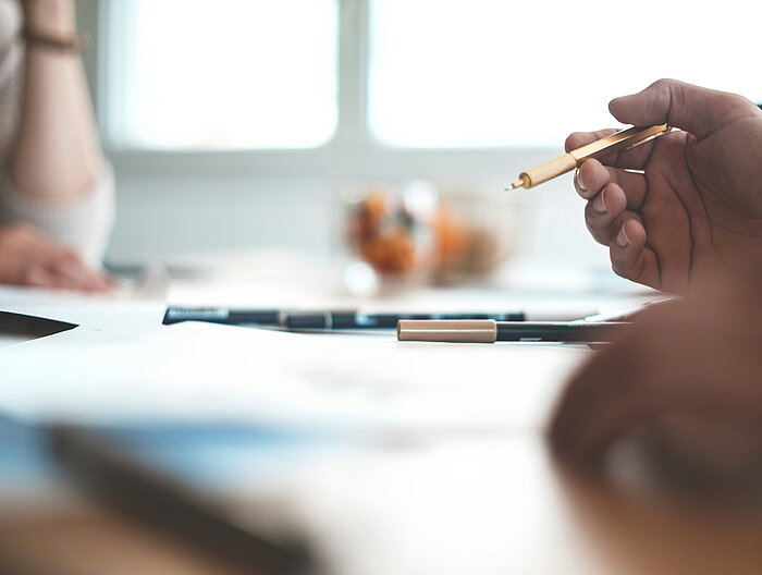 Meeting at a table with focus on pen and documents