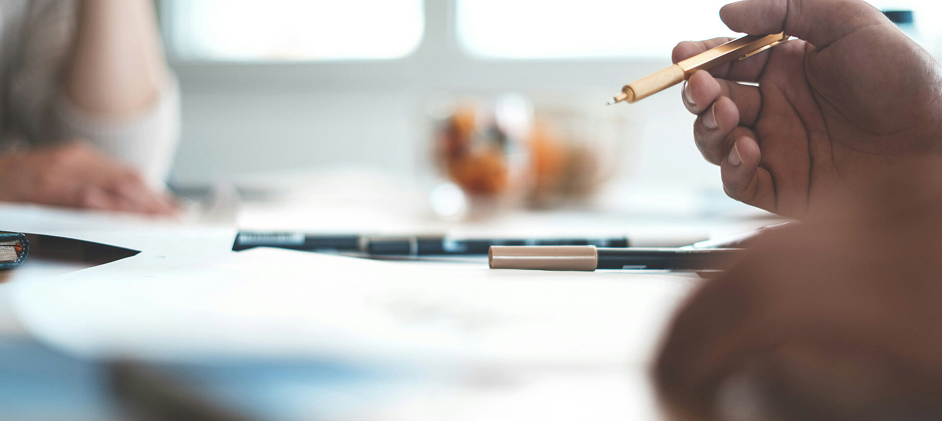 Meeting at a table with focus on pen and documents