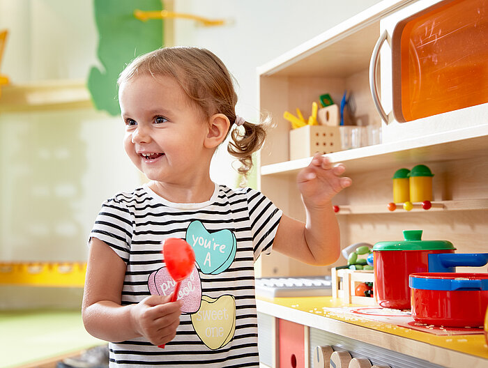Toddler playing in the play kitchen at the Lürzerhof, the family hotel in Austria for vacations with children.