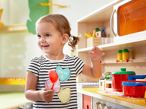 Toddler playing in the play kitchen at the Lürzerhof, the family hotel in Austria for vacations with children.