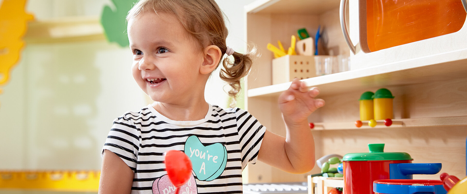 Toddler playing in the play kitchen at the Lürzerhof, the family hotel in Austria for vacations with children.