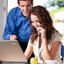 Zwei Kollegen arbeiten gemeinsam an einem Laptop im Seminarhotel Lürzerhof