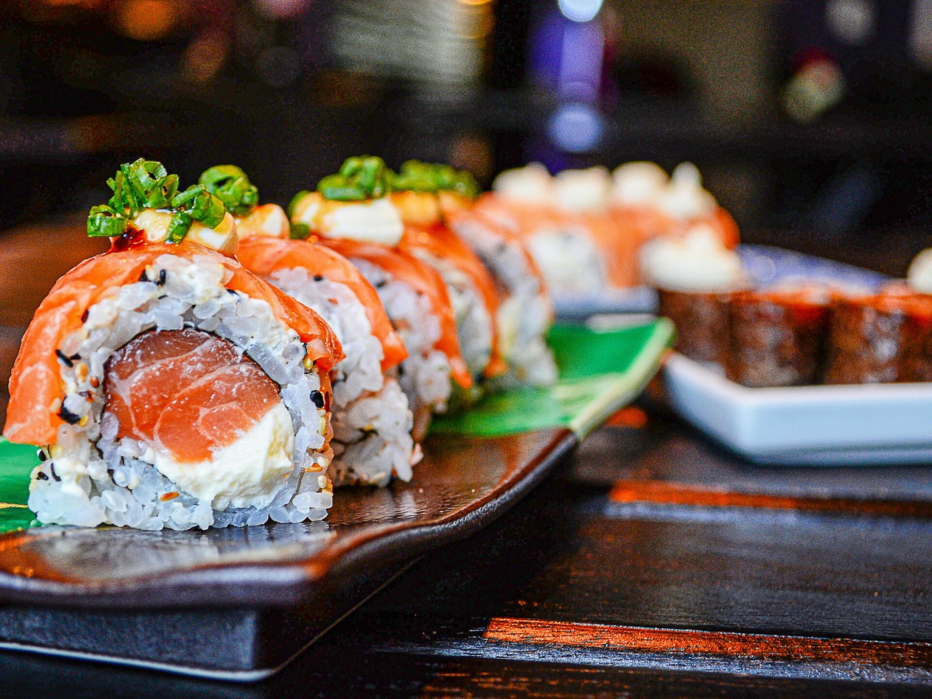 Sushi rolls with salmon and cream cheese served on ceramic plates