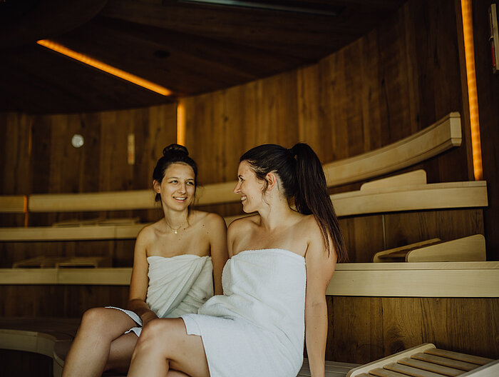 Two women are sitting in the sauna at the Lürzerhof wellness hotel in Salzburg.